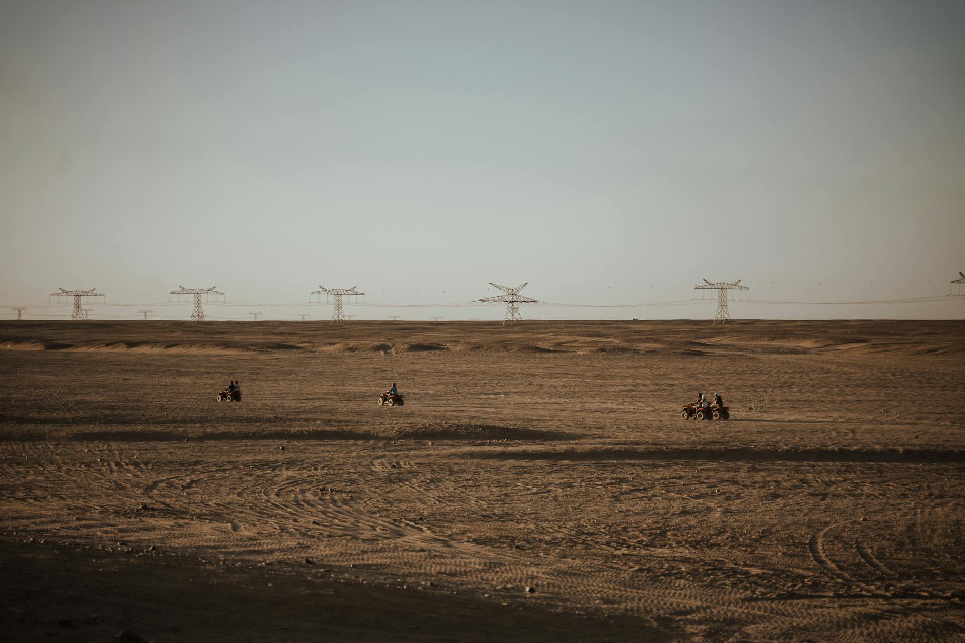 people riding quad bikes in a desert